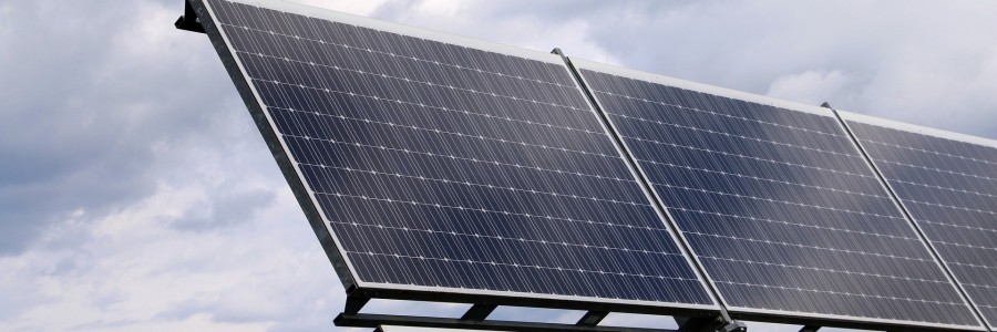 Image of solar panels an a blue sky with fluffy clouds