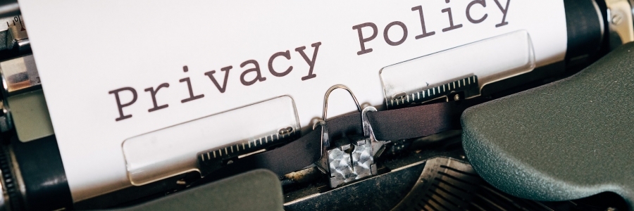 A typewriter is pictured with a sheet of white paper that reads "privacy policy"