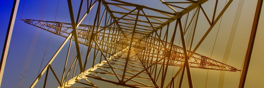 A picture of a steel transmission line tower as it would look from underneath when staring at the sky. The background fades from blue to yellow, top left to bottpm right.